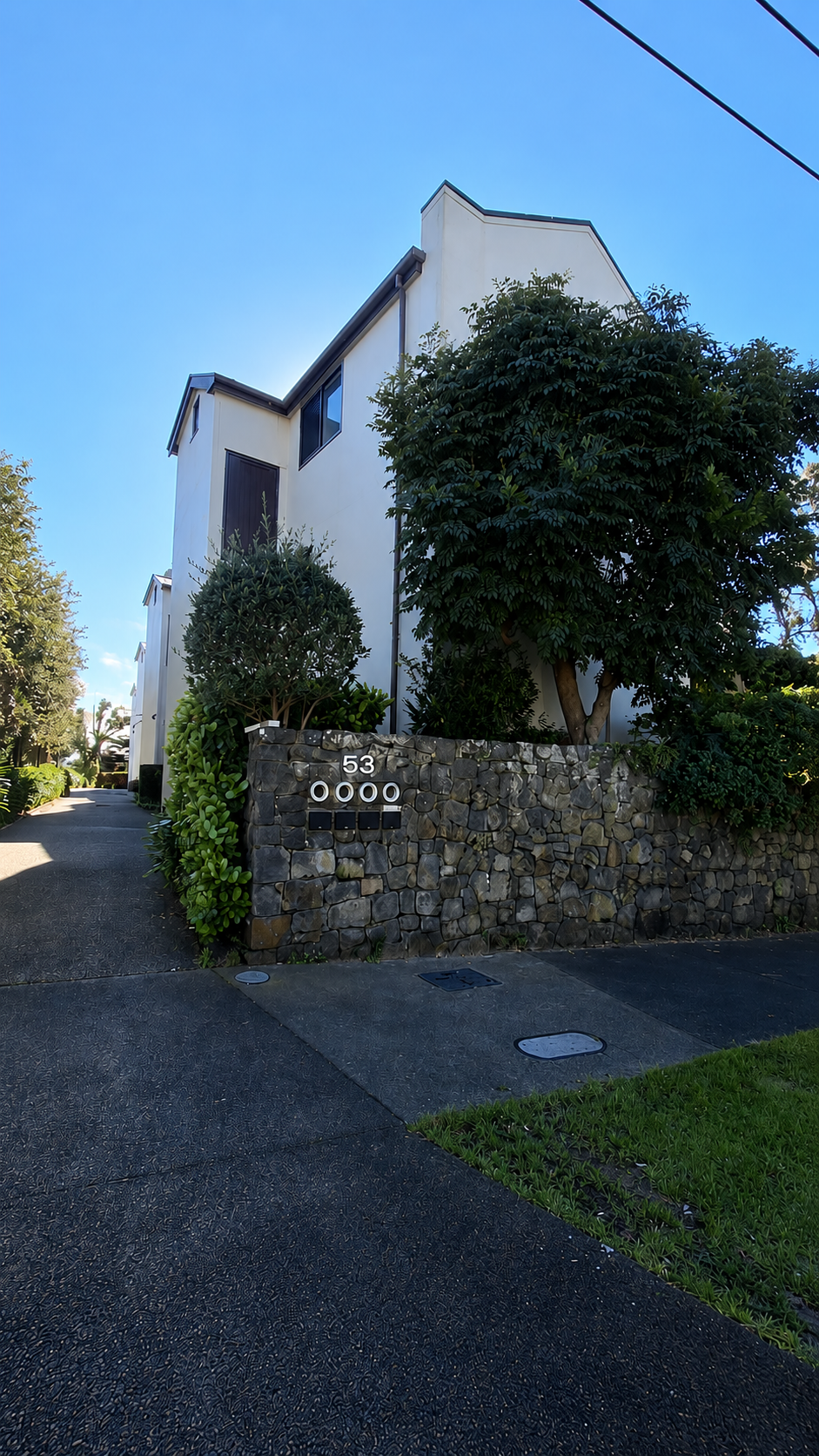 Tidy Auckland townhouse exterior with stone wall and letterboxes maintained by TradePlus handymen